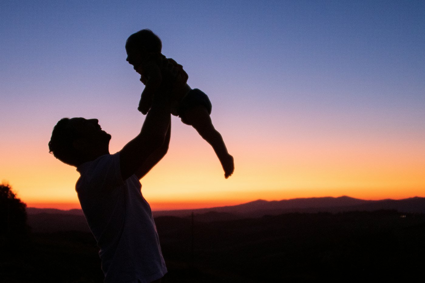 Father lifting his child at sunset - specific injury cover